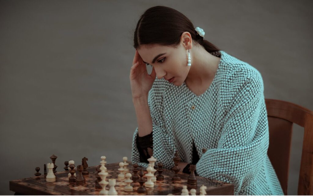 pensive ethnic woman thinking on chess move