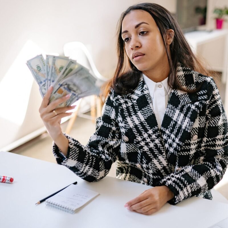 a woman in plaid coat holding money